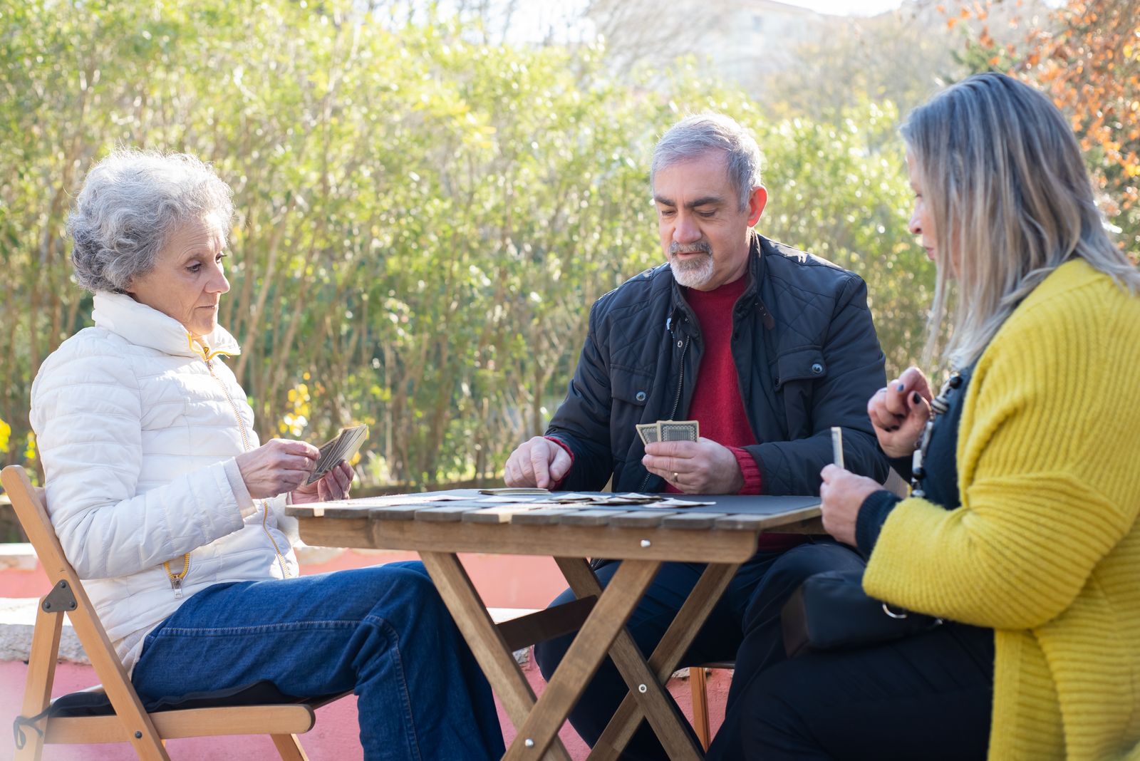 A group of older adults playing cards together at a table